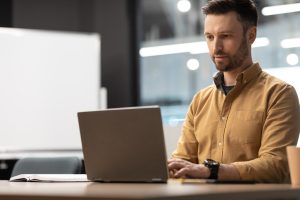 Mężczyzna pracujący nad pozycjonowaniem wizytówki Google w Niemczech na laptopie